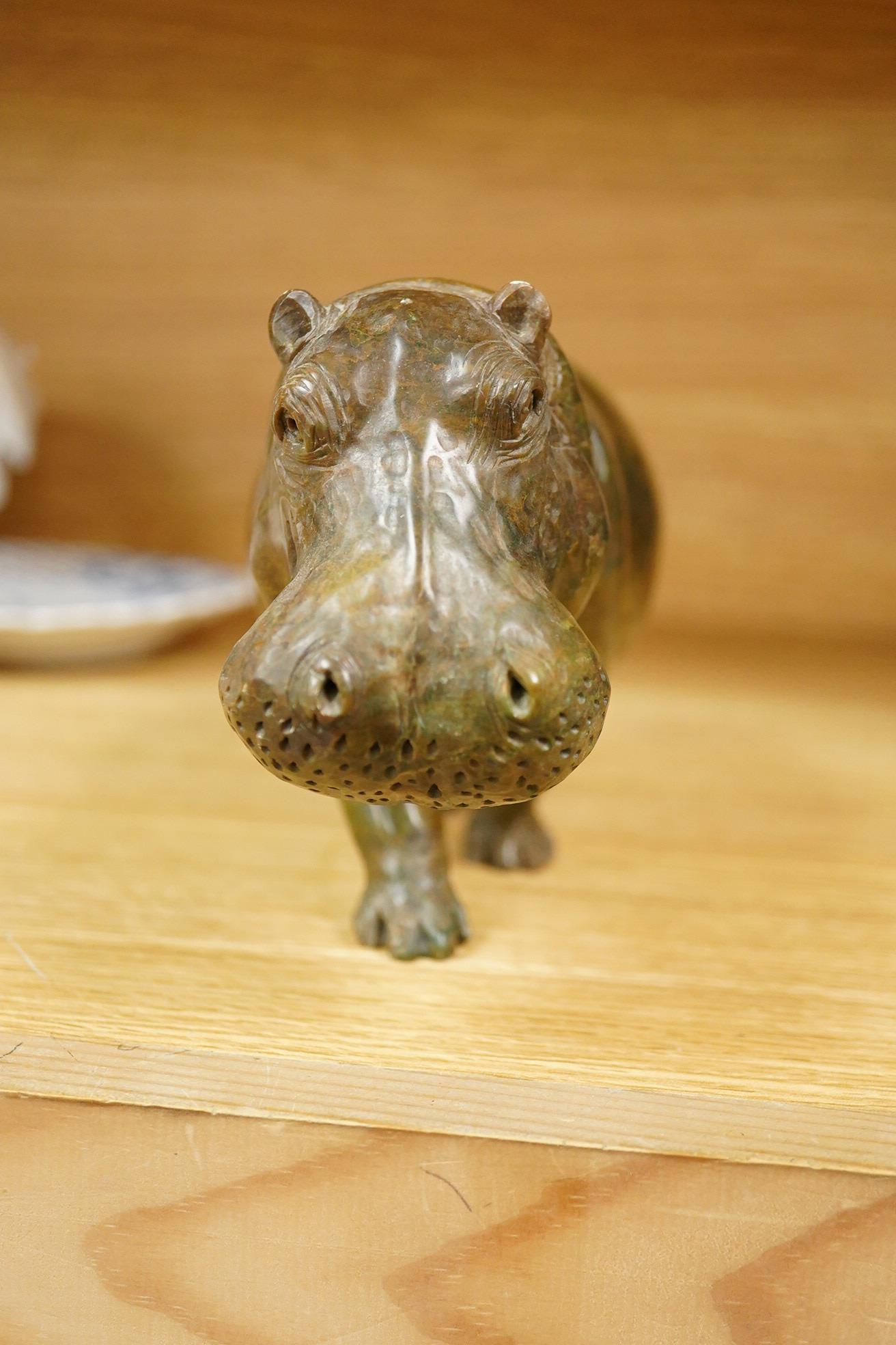 A carved serpentine study of a walking hippopotamus, incised initials to the underside 'E.S.', 24cm wide